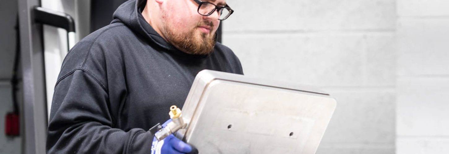 Engineering apprentice inspecting precision machined metal component